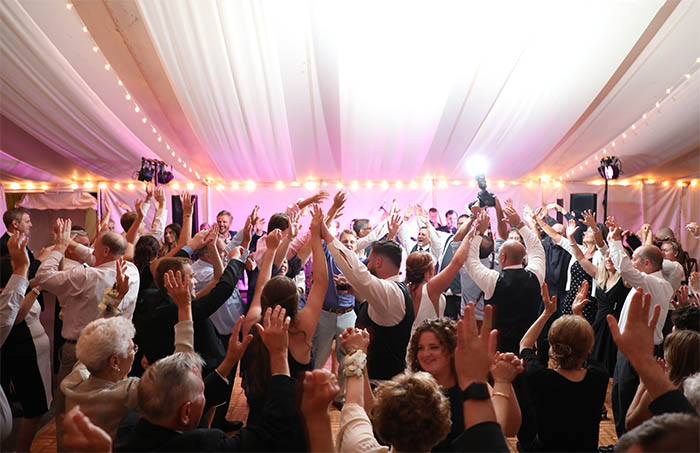 A packed dance floor with wedding guests dancing to the music of the Boston Premier Band
