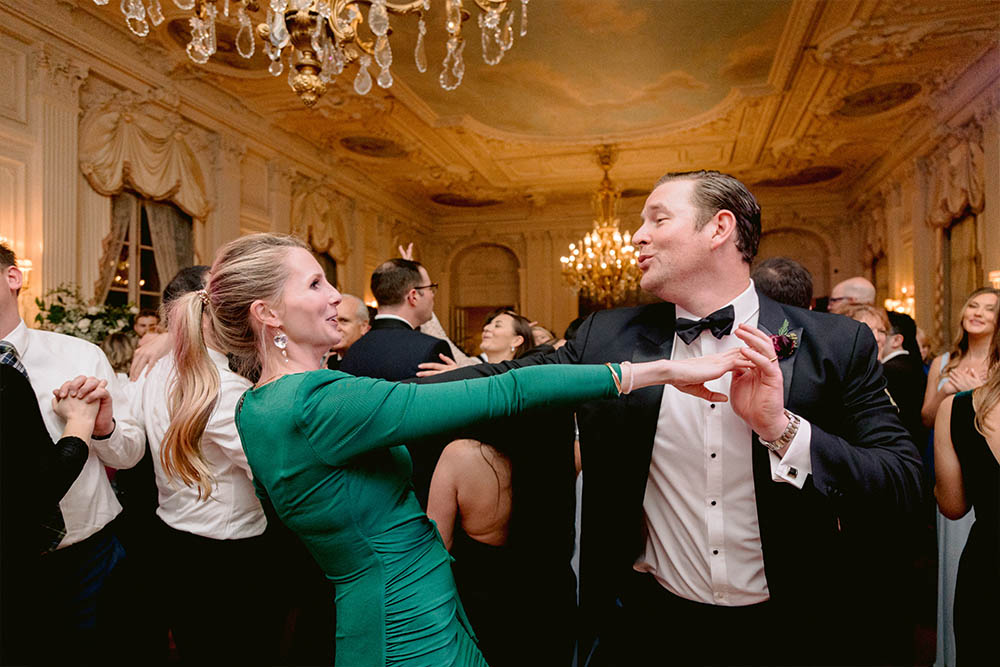 A couple is swing dancing to the music of Boston Premier