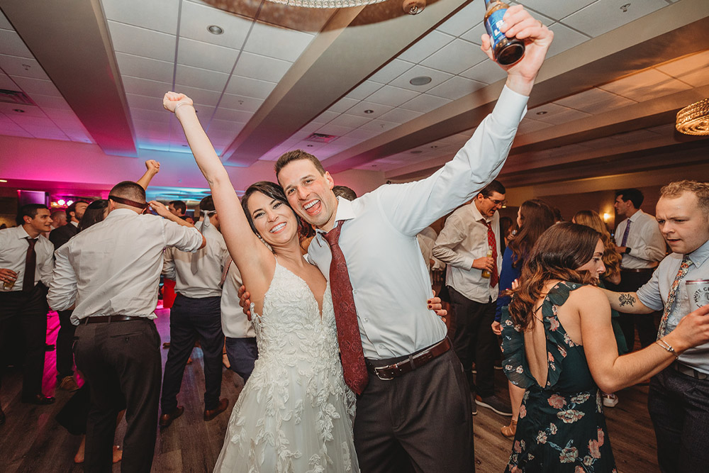 The happy couple raise their arms in joy as they dance to the music of Boston Premier