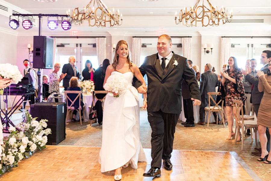 The bride and groom make their grand entrance into the ballroom.