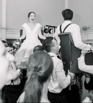 The Wedding Couple are lifted on chairs during their wedding reception.