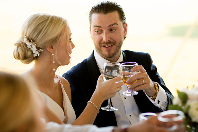 The bride and groom raise their toast glasses