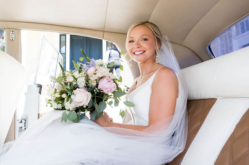The Bride sitting in a limousine holding her beautiful bouquet.