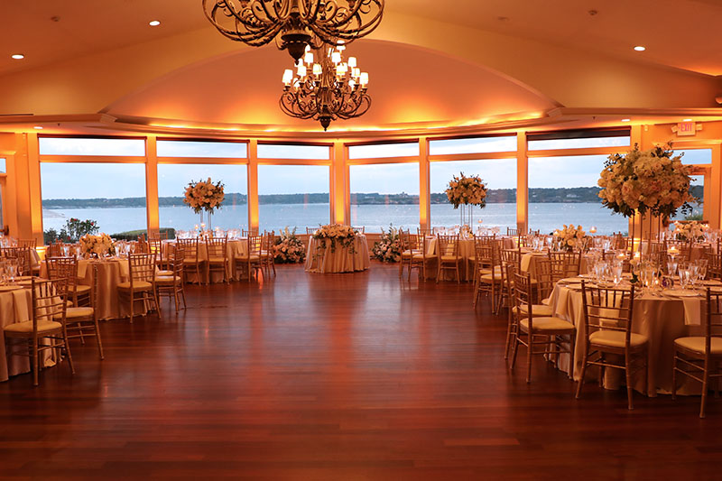 The grand ballroom of OceanCliff glowing in gold from the accent lighting