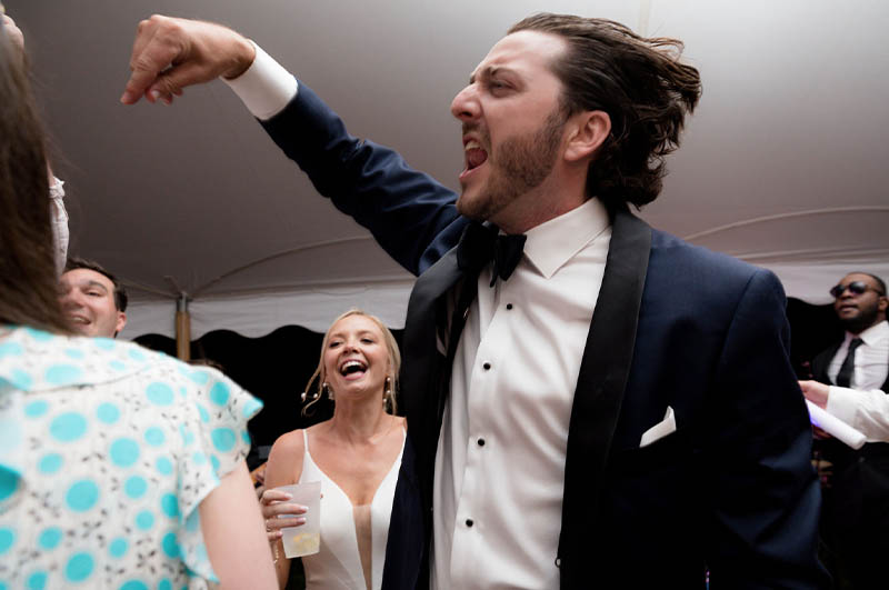 The groom pumping his fist as he dances at his wedding.
