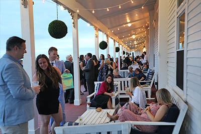 Wedding guests enjoy cocktails on the porch of the Spring House Hotel