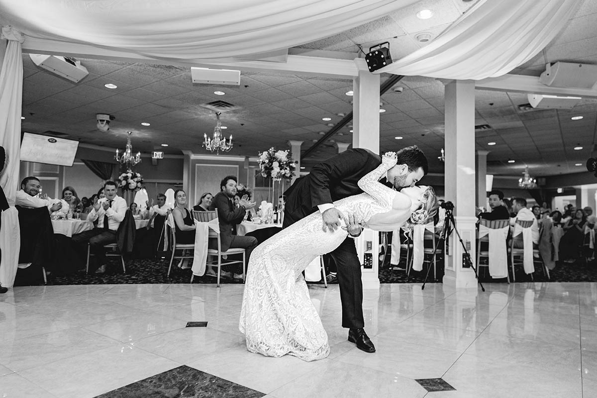 The groom dips his wife at the end of their first dance .