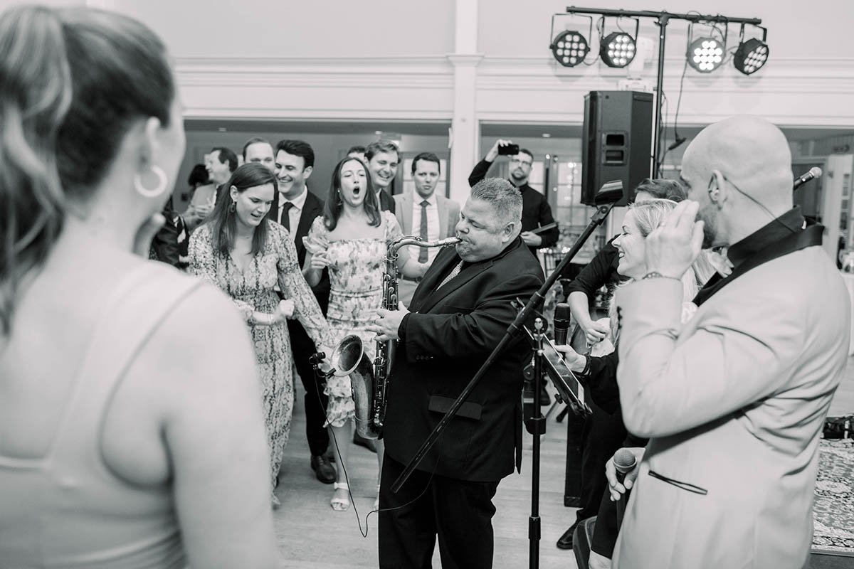 A saxophonist plays a solo as guests from a Nantucket wedding cheer him on.