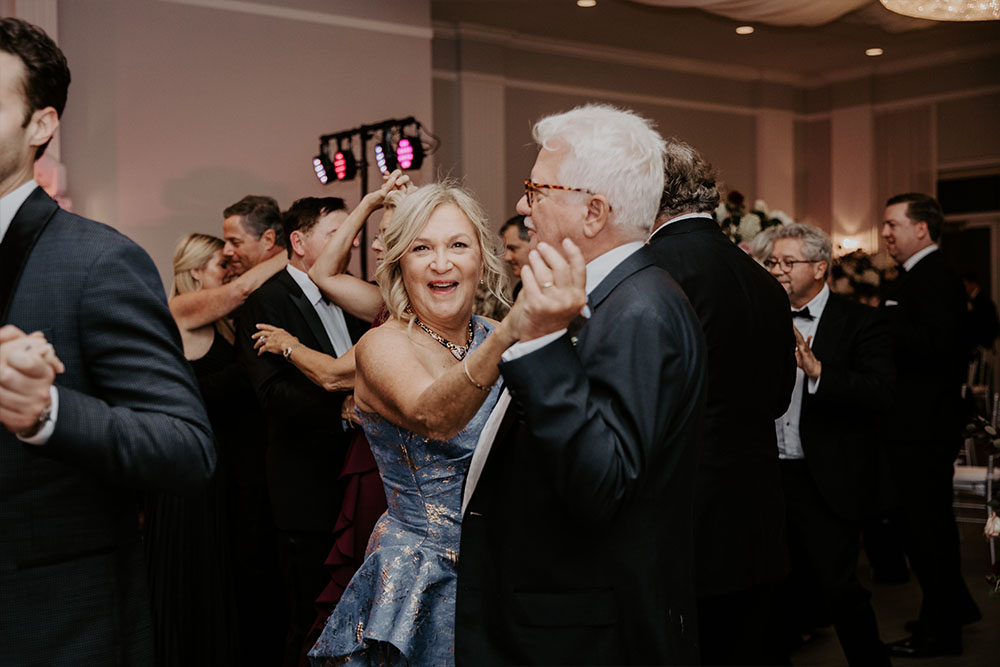 The Parents of the groom dancing together and smiling for the camera.