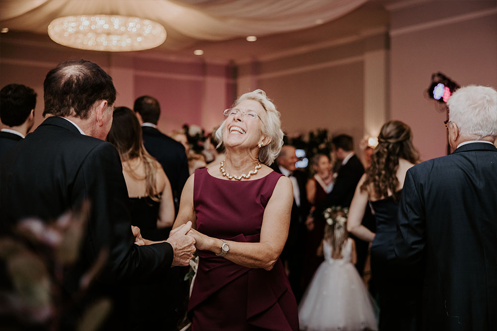 A woman laughing as she enjoys dancing at the wedding.