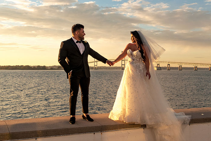 The Bride and Groom pose for a sunset photo in Newport