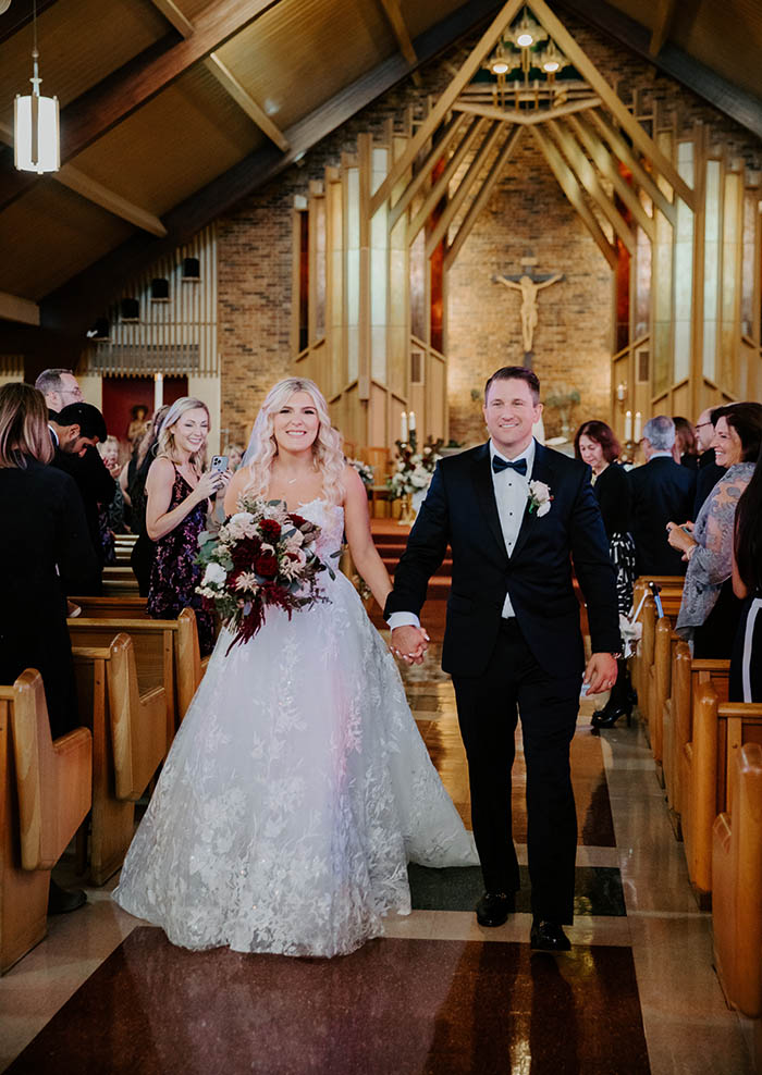 Peter and Alexandra smiling as they leave the chuch after their wedding ceremony