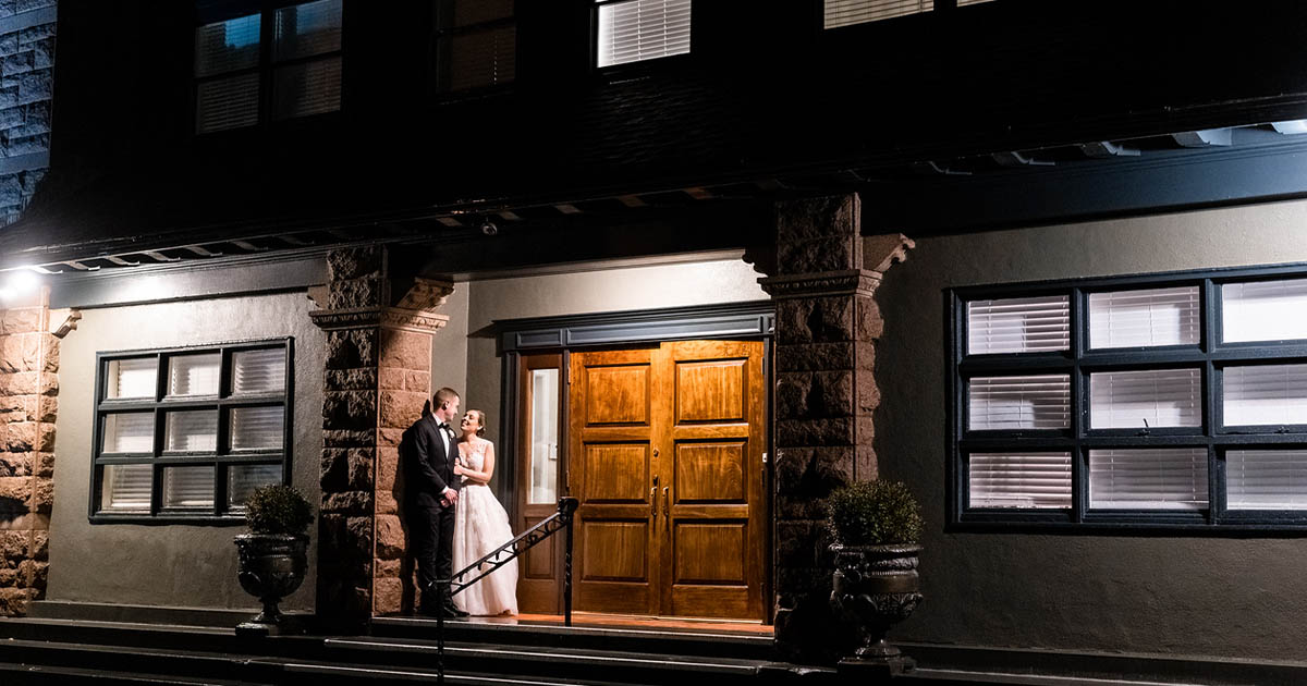The bride and groom share a private moment at the entrance of OceanCliff Hotel in Newport