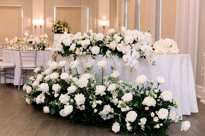 The head table adorned with white roses.