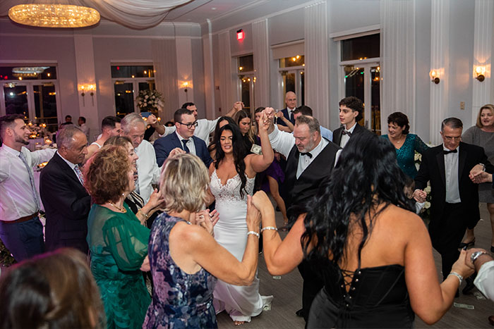 Guests surround the bride on the dance floor as the band plays.