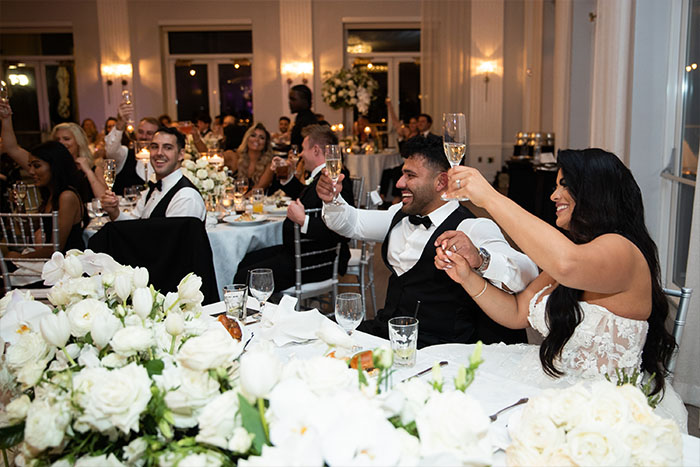 The bride and groom raise their toast glasses.