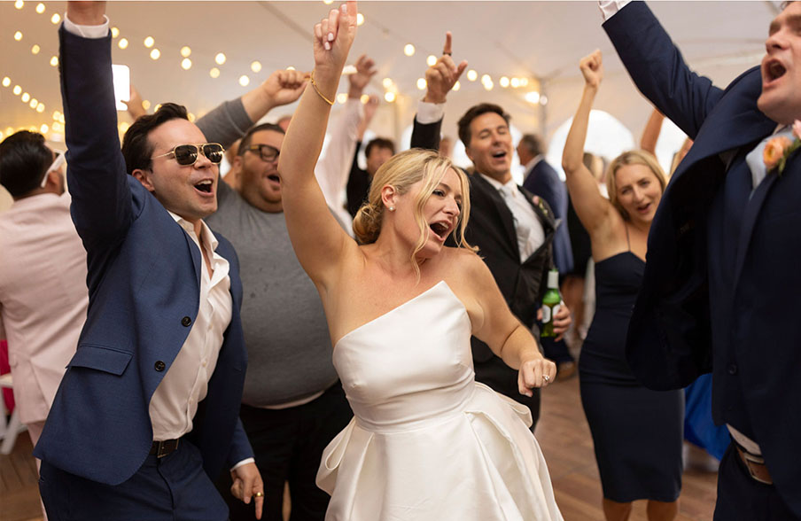 Caroline and Dan dancing among friends at their wedding.